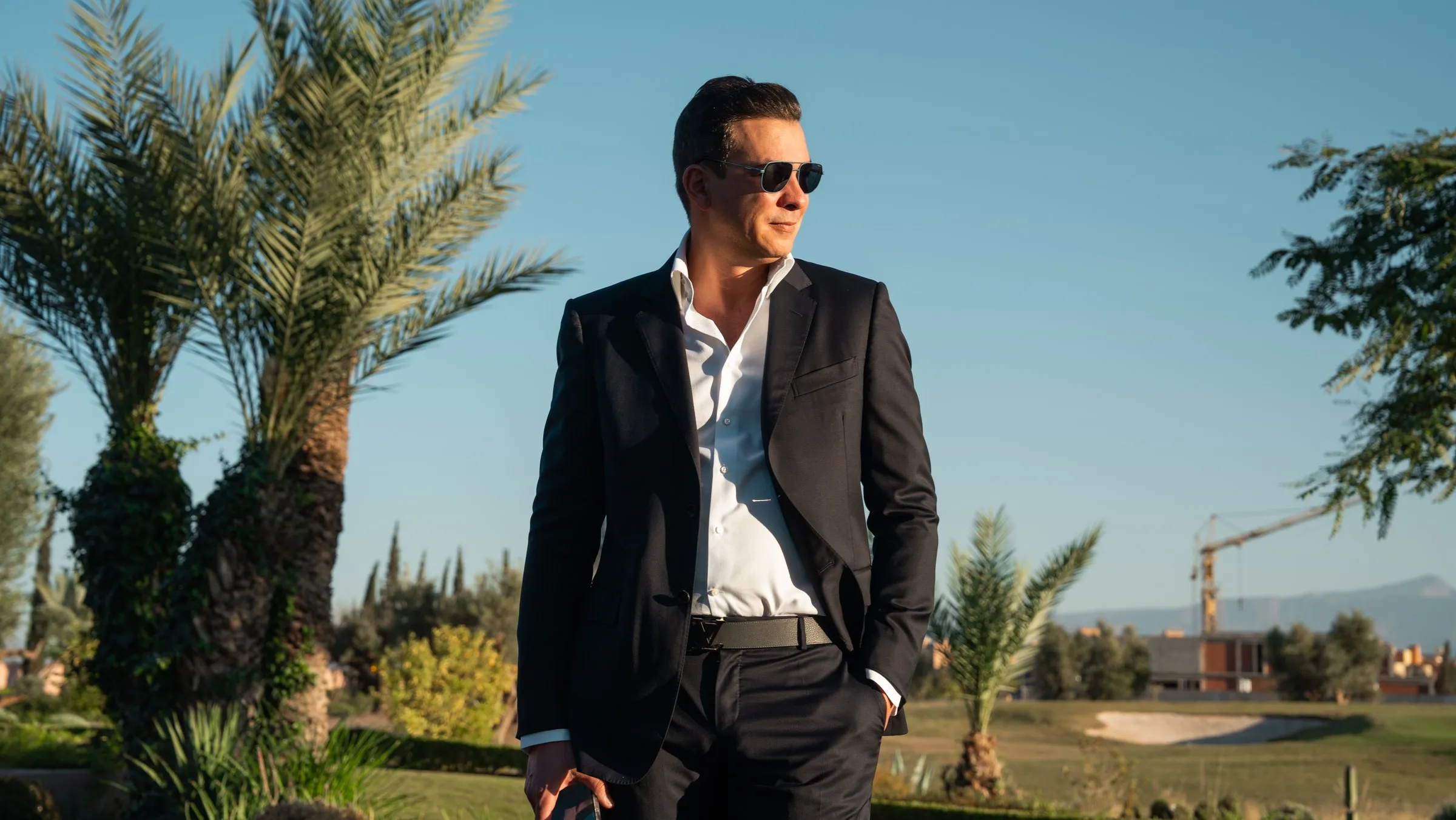 Tournage lifestyle : un chirurgien en costume sombre sur un golf de Marrakech