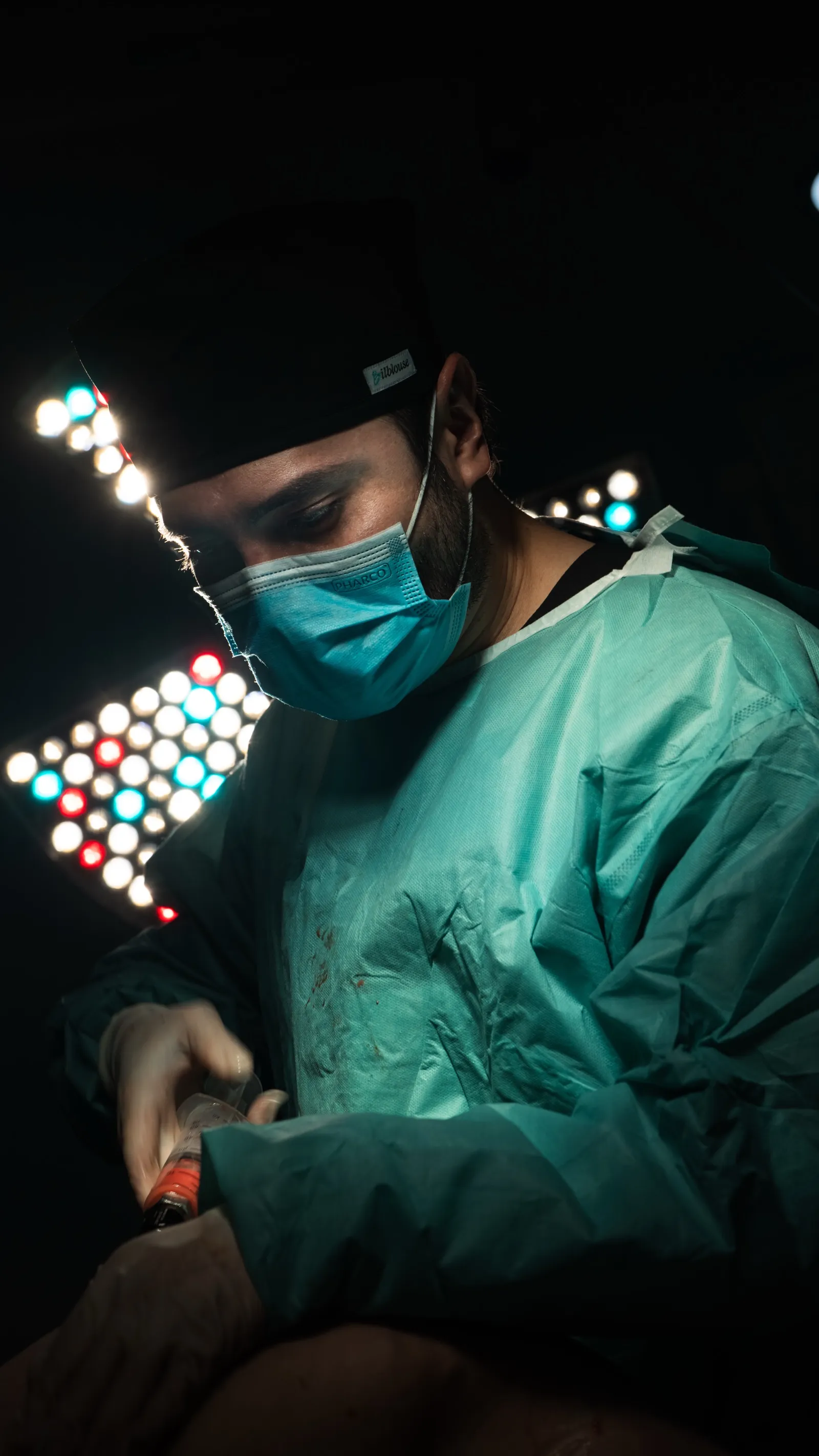 Chirurgien au travail devant les scialytiques colorés